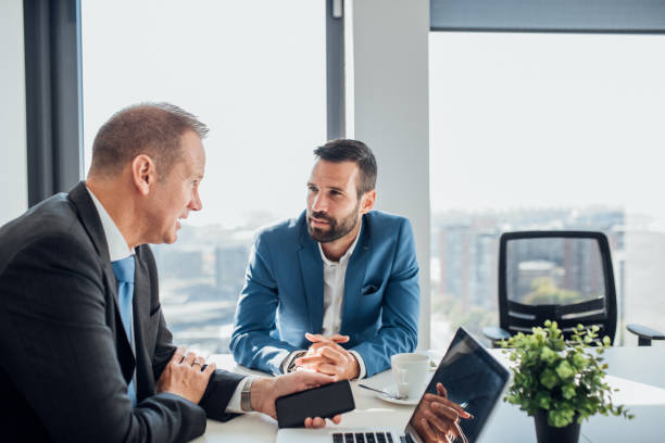 istock Coworkers using laptop and mobile phone 1065375356