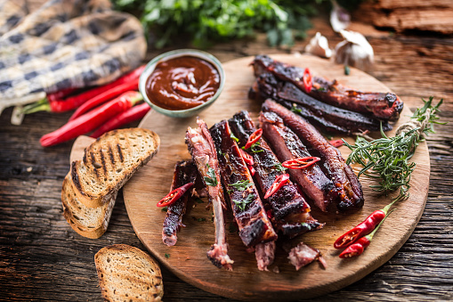 Tasty barbecue grilled pork ribs with chili pepers and parsley herbs.
