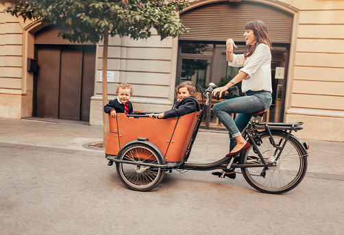 Mother riding bicycle with children on it