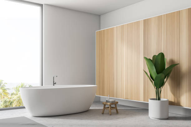 istock White bathtub near window in white wood bathroom 1065383562