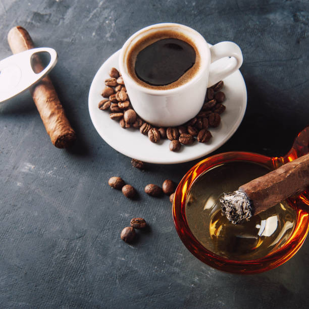 istock Cup of coffee, coffee beans, ashtray with cigar on dark background. 1065386164