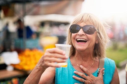 Portrait of a senior tourist woman delighted by the taste of freshly squeezed orange juice on farmer's market. Can Picafort, Majorca, Spain.
Nikon D850