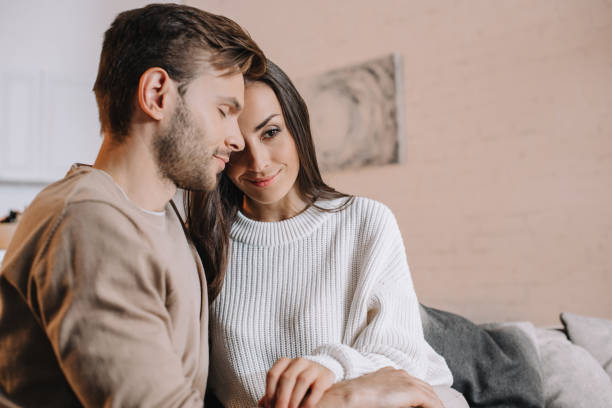 istock young couple cuddling on couch at home 1065392154