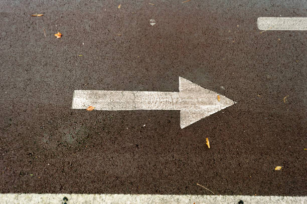 istock asphalt road with drawn arrows pointing to two directions. Making decisions and making choices 1065392502