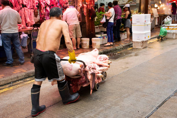 китайский мясник готовит мясо для продажи на местном рынке в гонконге, китай - market market stall shopping people стоковые фото и изображения