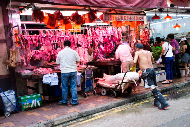 китайский мясник готовит мясо для продажи на м�естном рынке в гонконге, китай - market market stall shopping people стоковые фото и изображения