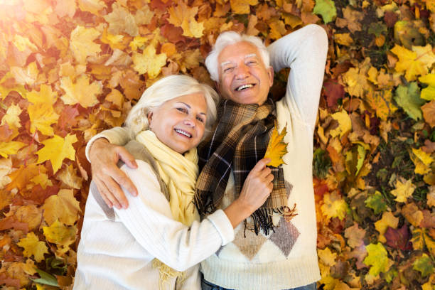 istock Elderly couple together in autumn park 1065395302