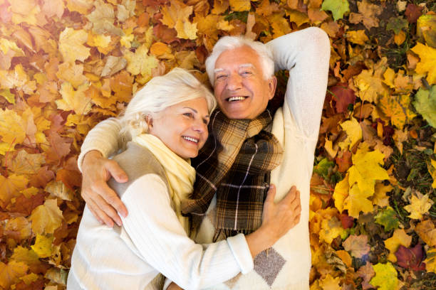 istock Elderly couple together in autumn park 1065396880