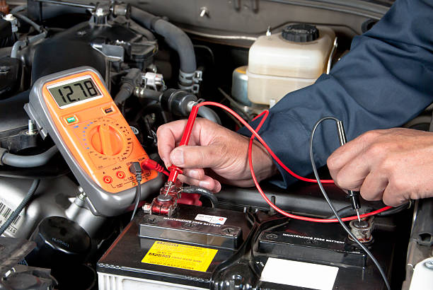 автомеханик проверяет напряжение батареи автомобилей - car battery стоковые фото и изображения