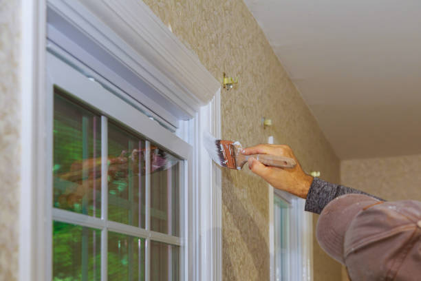 istock Hand with paintbrush painting a window trim white 1065397948