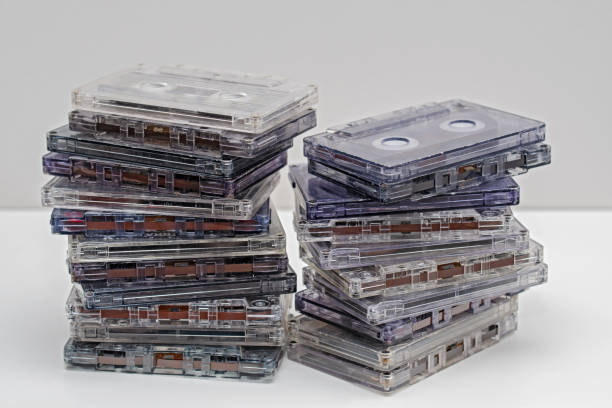 istock Stack of old dirty audio cassettes on the white shelf. 1065398184