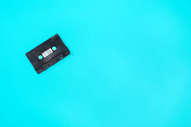 istock Retro black plastic audio cassette laying on the green metal table. 1065398192