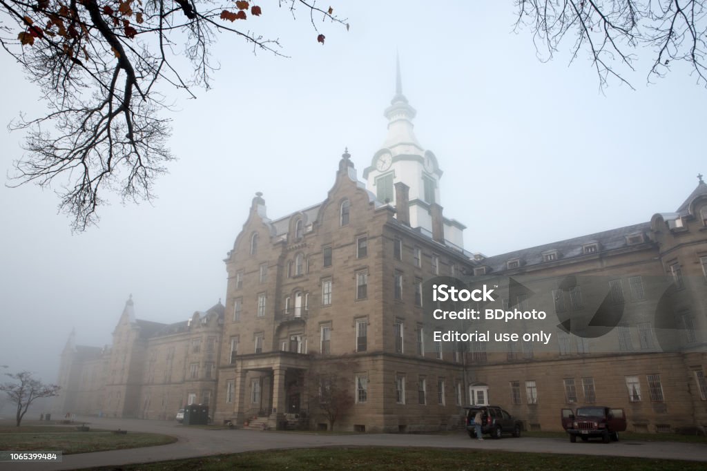 Historic mental hospital in Weston, Va (Trans-Allegheny Lunatic Asylum) Weston, Virginia, USA -  November 4, 2018.  History buffs and believers in the paranormal visit the century old facility in the early morning hours.  It is believed to be one of the most haunted places in the U.S. Psychiatric Hospital Stock Photo