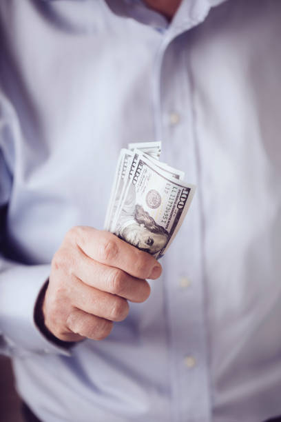 istock American one hundred dollar bills in a male hand 1065407018