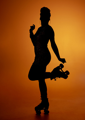 Studio shot of a woman in silhouette using roller skates