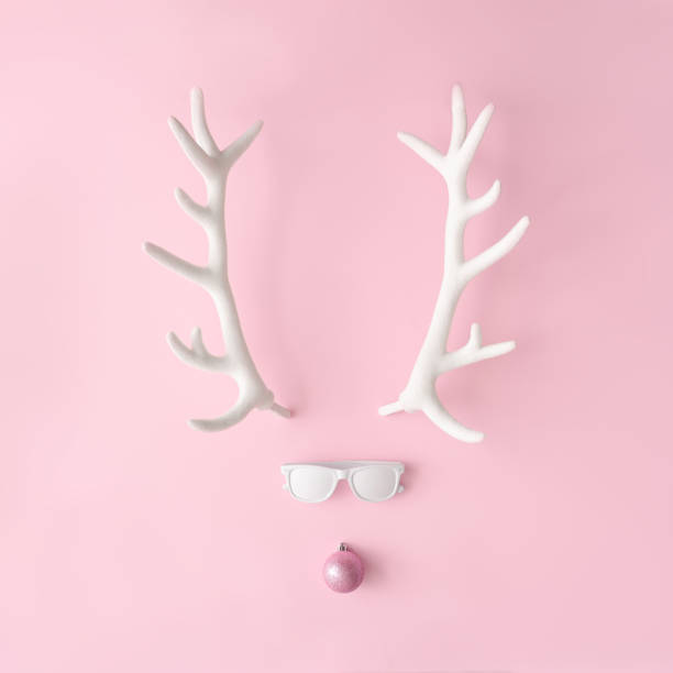 istock Santas reindeer face with hipster sunglasses on pink background with copy space. 1065408972