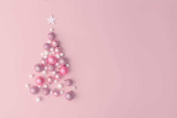 Christmas composition. Christmas tree made of pink ball decoration on pink table background. Flat lay, top view, copy space. New Year sale card. pink christmas tree stock pictures, royalty-free photos & images
