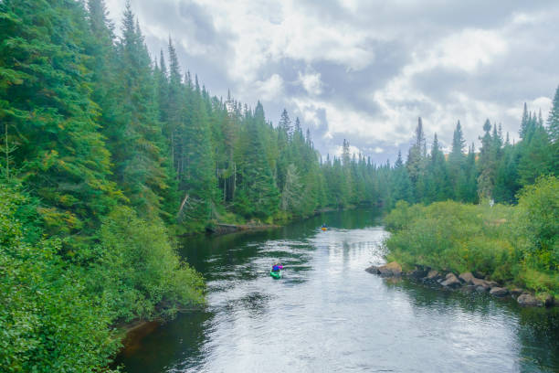A caucasian woman and child canoeing on a beautiful mountain lake.