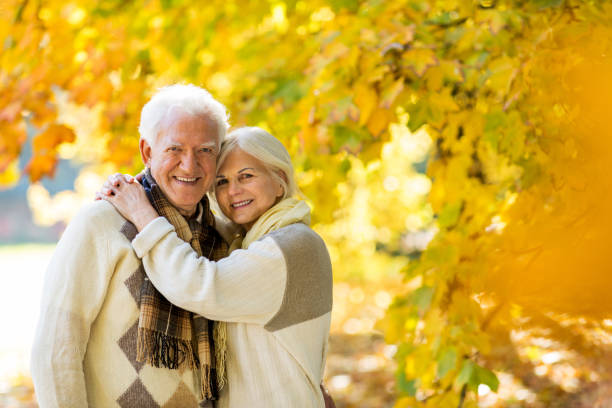 istock Elderly couple together in autumn park 1065416178