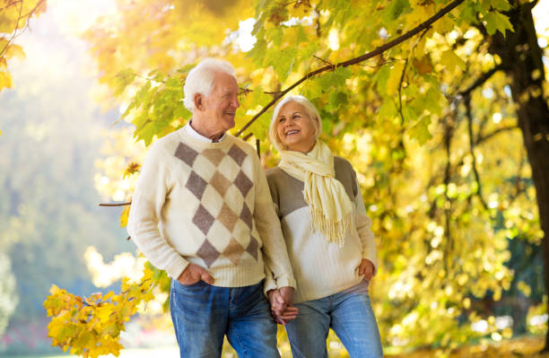 istock Elderly couple together in autumn park 1065416234