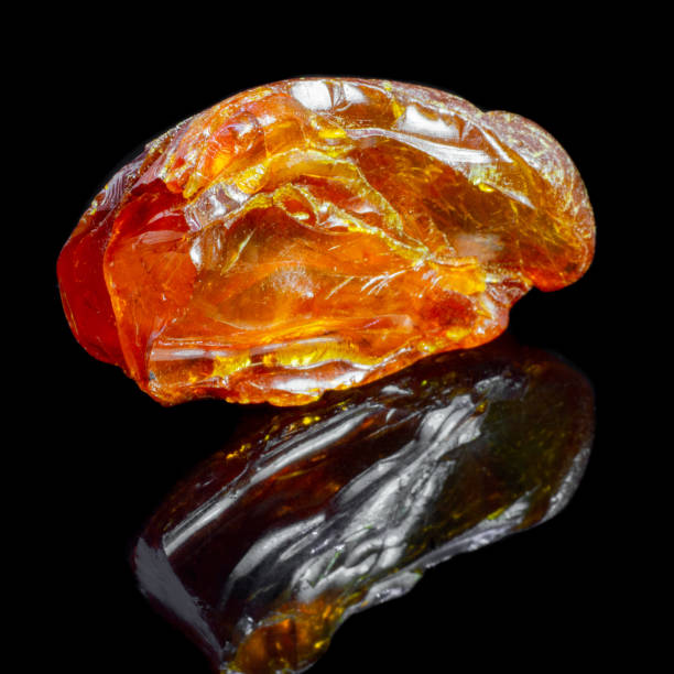 istock Natural piece of amber on a black background with reflection 1065416914