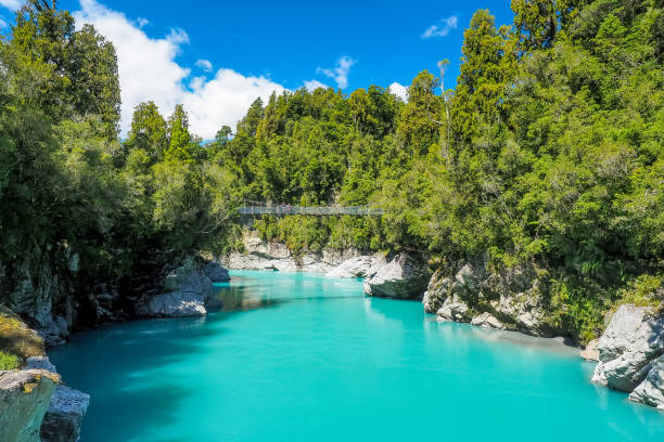 The swing bridge is on the stunning turquoise blue river at Hokitika Gorge in the South Island of New Zealand. stock photo