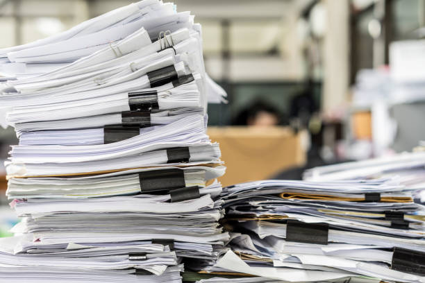istock The stack of paper lay on a messy office table. 1065429016