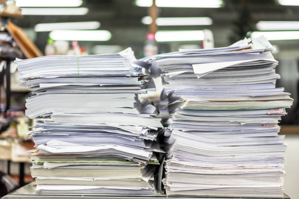 istock The stack of paper lay on a messy office table. 1065429376