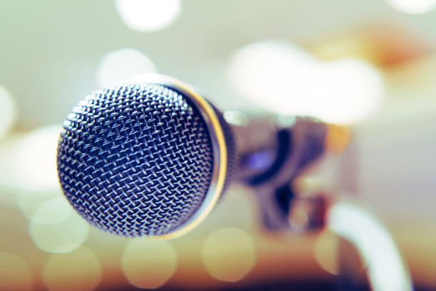 istock Microphone in the background with bright lights on the singing contest stage. 1065432556