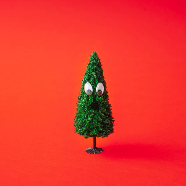 istock Christmas tree with googly eyes on a red background. 1065433236