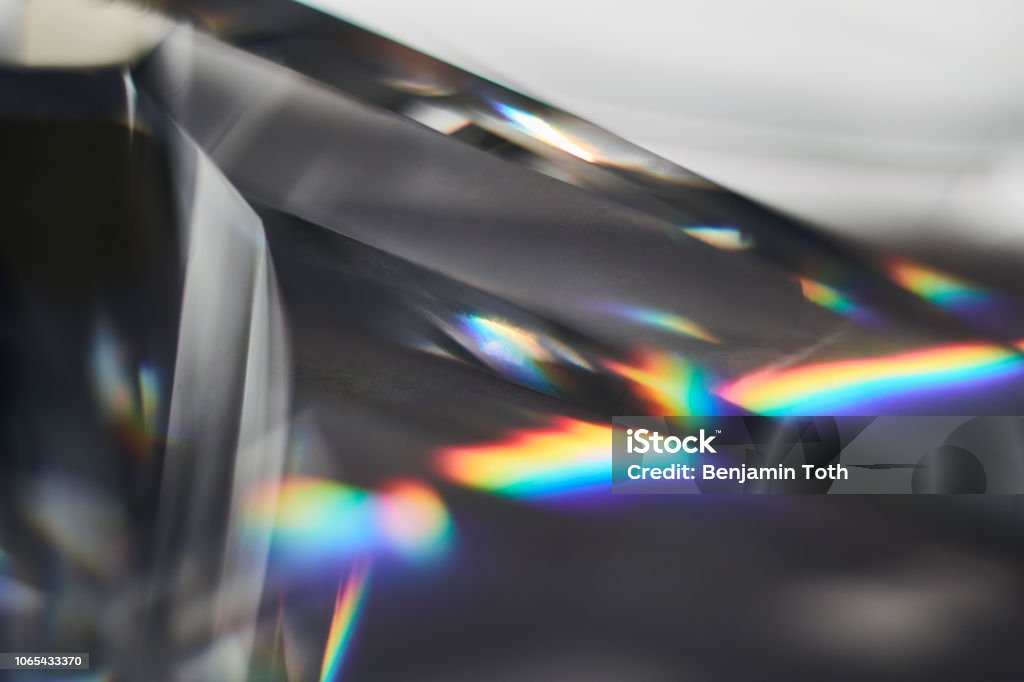 Prism dispersing sunlight splitting into a spectrum macro view Glass - Material Stock Photo