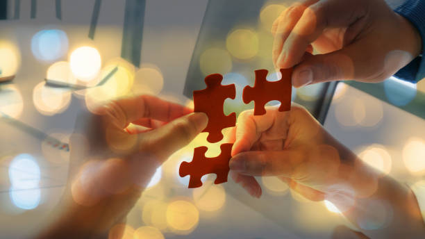 istock Hand team put missing jigsaw puzzle on the air 1065433766