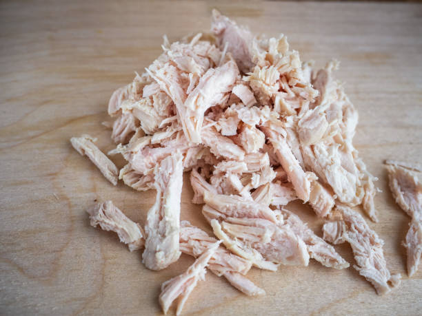 Chopped boiled chicken. Salad blanks. Chopped boiled chicken. Salad blanks. Finely chopped boiled chicken lies on a light-colored kitchen board. Salad blanks. finely stock pictures, royalty-free photos & images