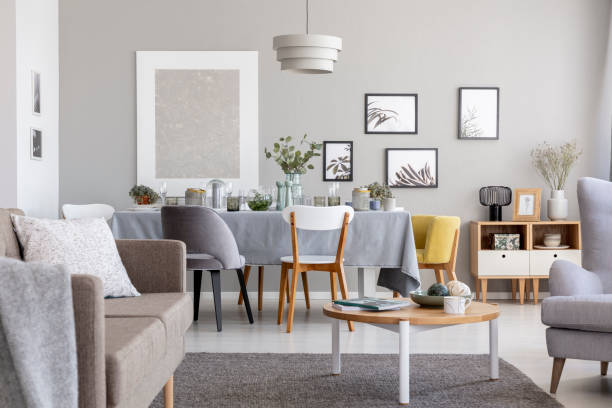 istock Elegant living room interior with sofa, dark carpet, simple gallery and dining table set for holiday celebration in the real photo 1065437886