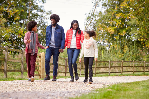 istock Mixed race family walking together on a country path, low angle 1065440256