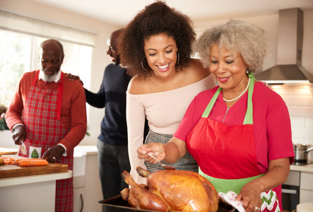 raza mixta senior y jóvenes adultos miembros de la familia hablando en la cocina preparando la cena de navidad, de cerca - son in law fotografías e imágenes de stock