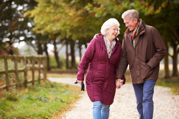 istock Active Senior Couple On Autumn Walk On Path Through Countryside 1065444238