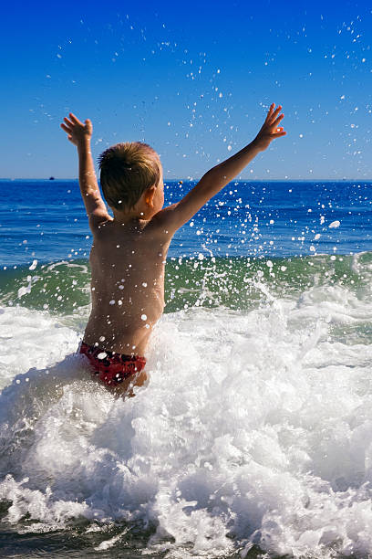 istock young child playing in the waves 106544677