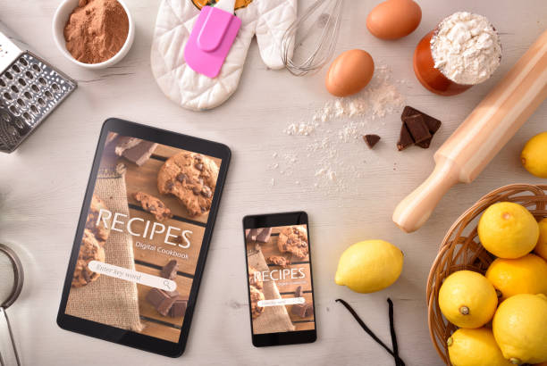 Using digital cookbook app in devices in pastry stock photo