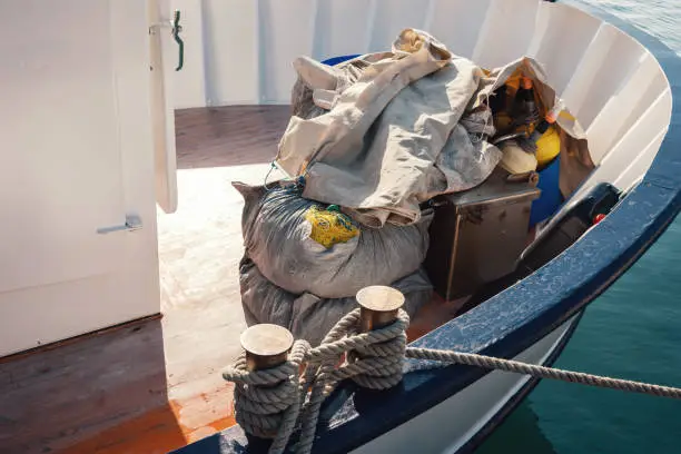 Photo of Fishing Equipment Covered In Tarp On Moored Fishing Boat In Greek Harbor At Sunset