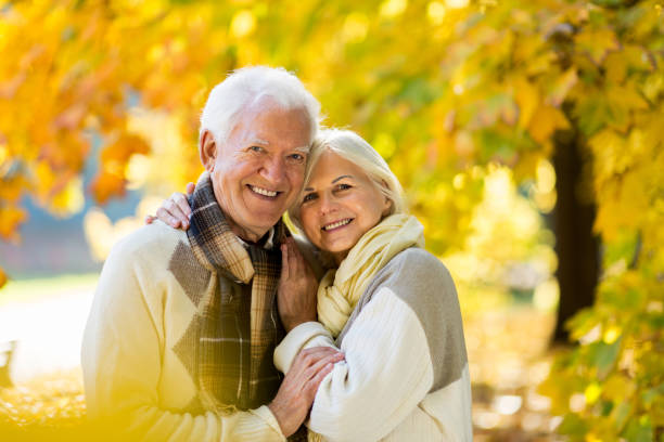 istock Elderly couple together in autumn park 1065450230