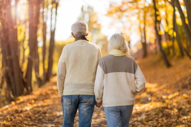istock Elderly couple together in autumn park 1065450454
