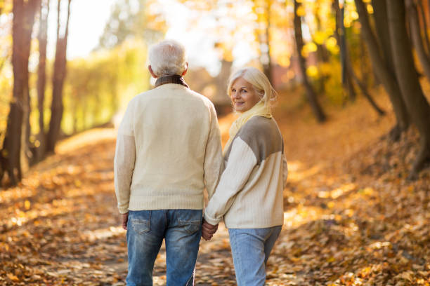 istock Elderly couple together in autumn park 1065450554