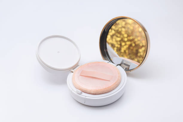 foundation powder cushion with beige puff and shining golden reflection on white background - powder puff imagens e fotografias de stock