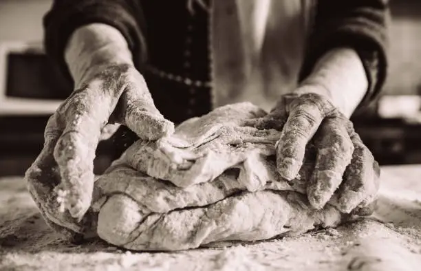 old italian grandma making pasta in the kitchen sepia effect