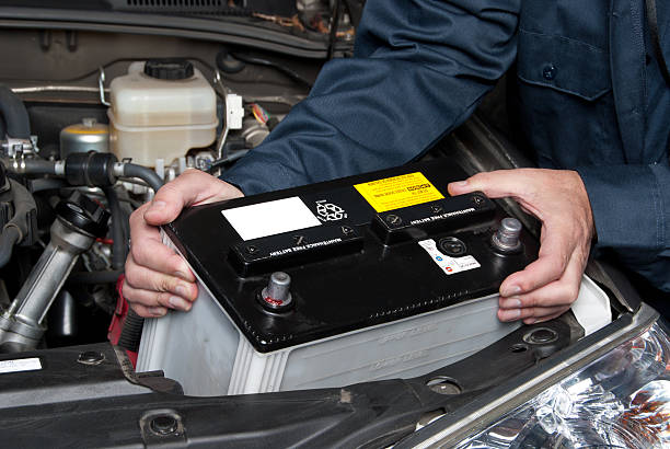 Auto mechanic replacing car battery stock photo