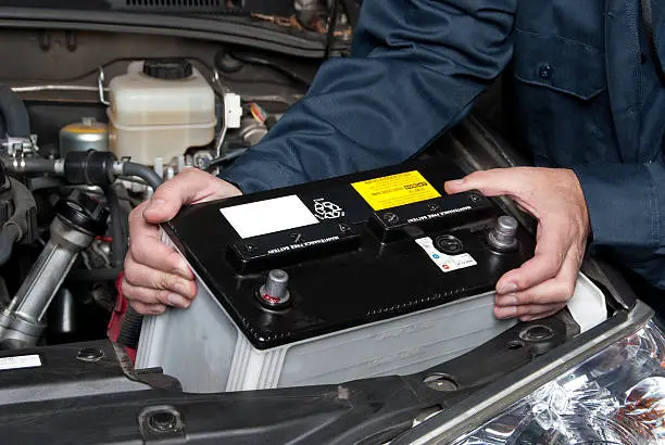 Photo of Auto mechanic replacing car battery