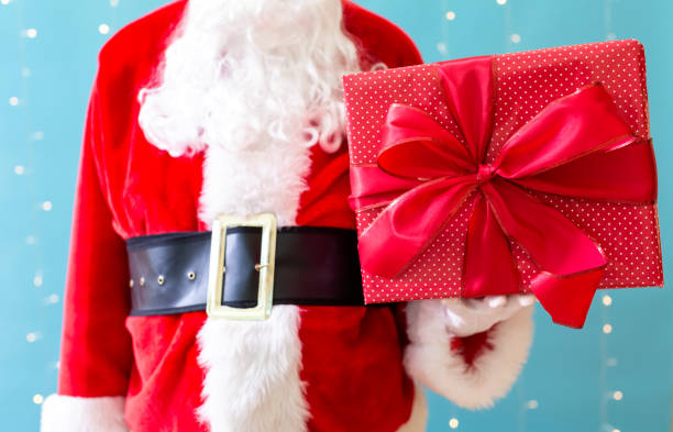 istock Santa holding a Christmas gift 1065457980