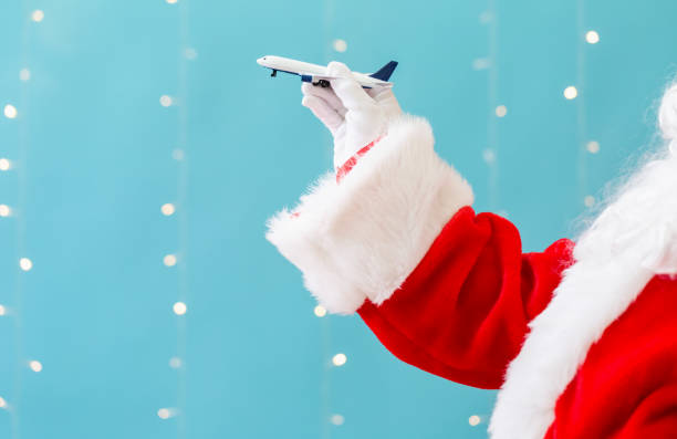 istock Santa holding a toy airplane 1065458016