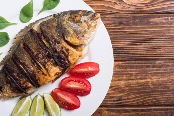 istock Fried fish dorado with lime , tomatoes and spinach 1065458402